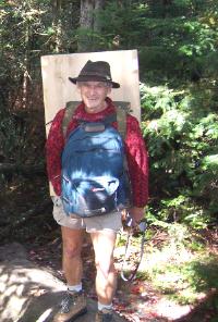 Volunteer Larry Coon carrying plywood for the new door